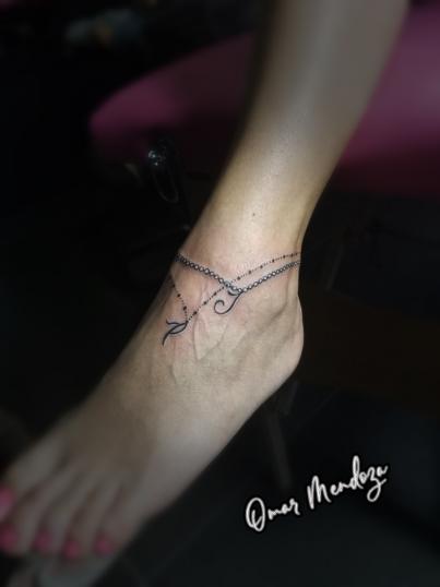 Pulcera en el pie con iniciales tatuaje realizado por Omar Mendoza