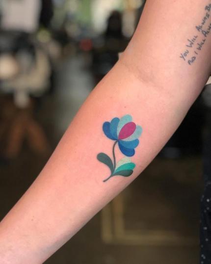 Flor acuarela tatuaje realizado por Megan Massacre