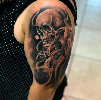 Cráneo y guitarra black and grey tatuaje realizado por Izrael VG