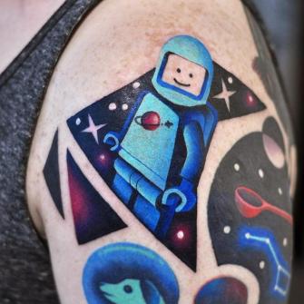 Lego spaceman tatuaje realizado por David Peyote