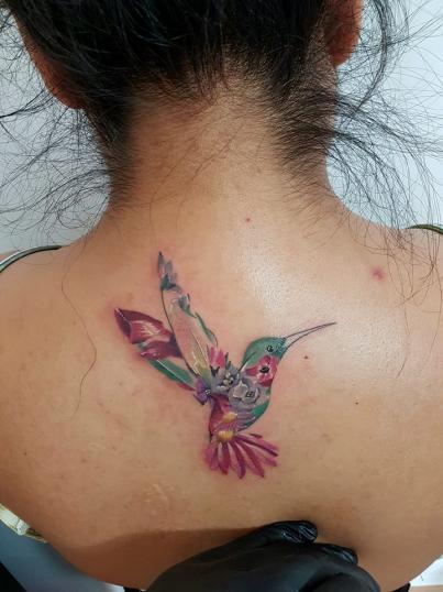 Colibrí con flores tatuaje realizado por Fiker Adrian