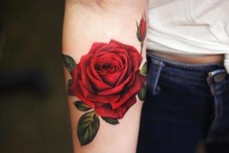 Rosa en el brazo, realismo a color tatuaje realizado por Joice Wang