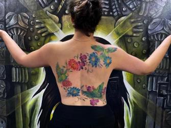 Aves y flores de colores tatuaje realizado por Paty Escobar