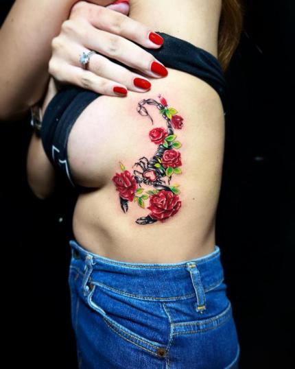 Tatuaje de escorpión con rosas en las costillas realizado por Hendric Shinigami tatuaje realizado por Hendric Shinigami