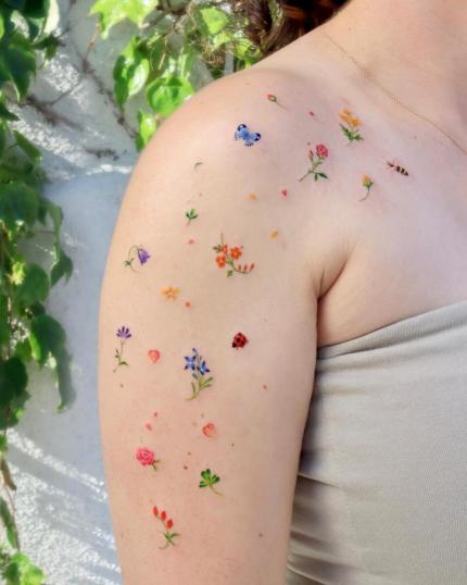 Tatuaje de lluvia de flores en el brazo realizado por Ovenlee, minitatuajes tatuaje realizado por Ovenlee