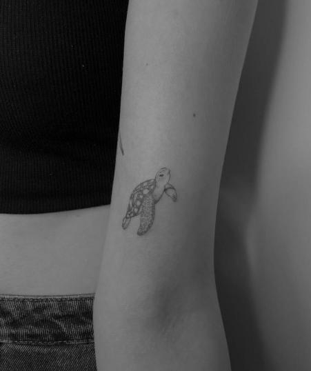 Mini tatuaje de tortuga en el brazo blackwork realizado por Paula Kmica tatuaje realizado por Paula Kmica