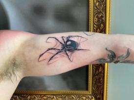 Tatuaje de araña negra en el brazo realizado por Om Zu Art tatuaje realizado por Om Zu Art